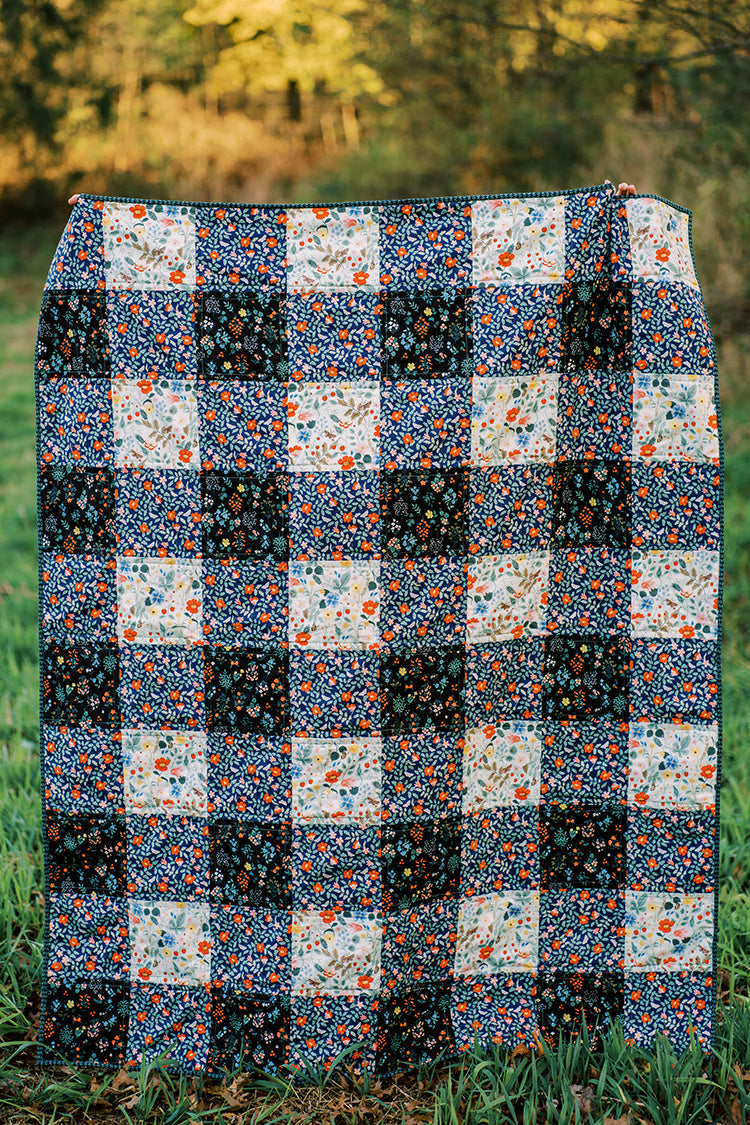 gingham patterned quilt in forest