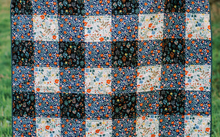 gingham patterned quilt in forest