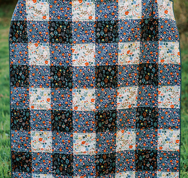 gingham patterned quilt in forest